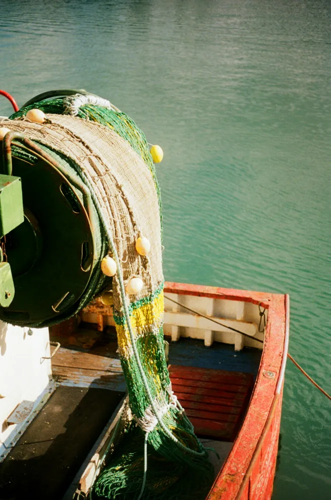 Rede de pesca recolhida no convés de um barco.