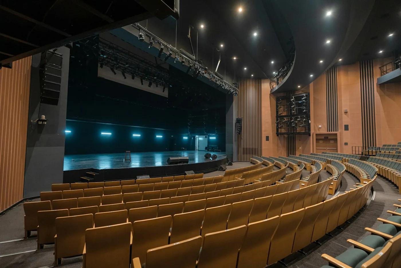 Palco e fileiras de assentos de um teatro vazio.